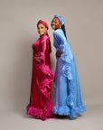 Women wearing the Ola Buubu satin gowns with ruffle edges, long sleeves, high neckline, and matching headwraps.