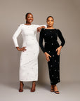 Women wearing the Zola maxi dress with bateau neckline, rhinestone embellishments, long sleeves, deep V-back plunge, and hemline slit.
