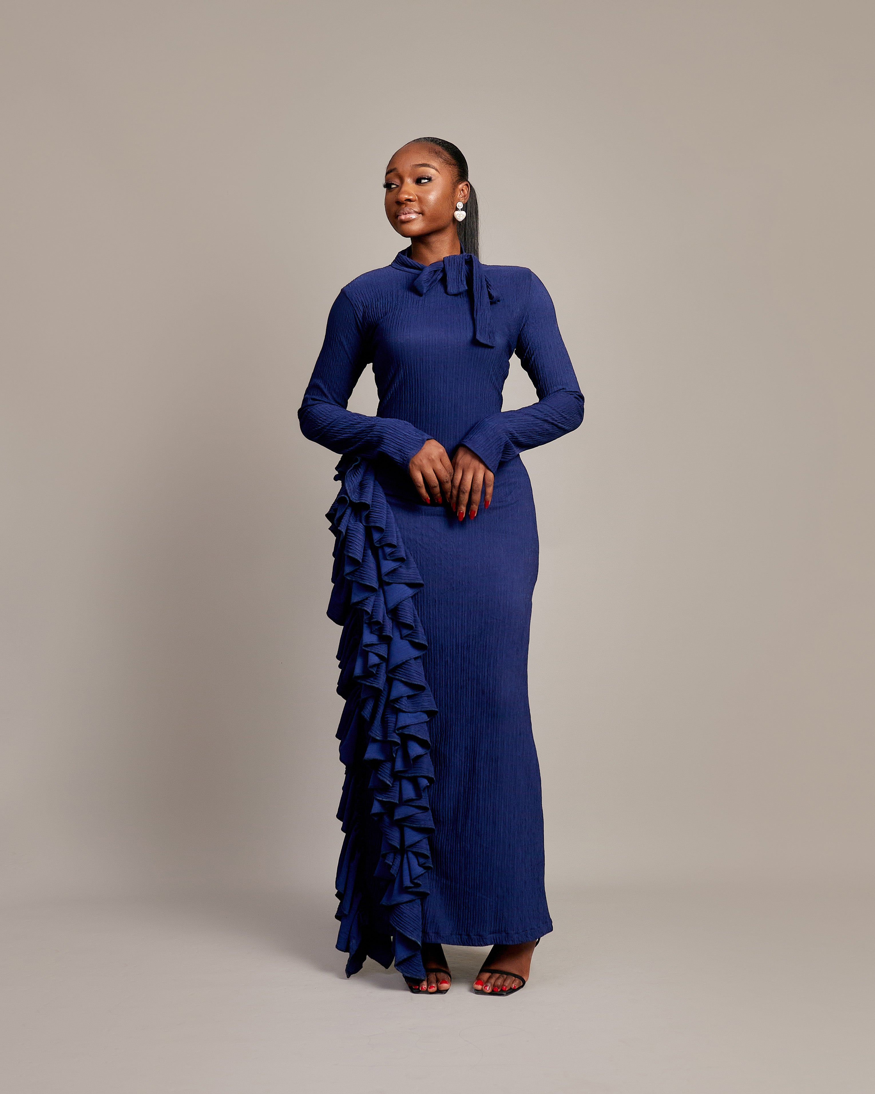  Amira Dress in navy blue with high neckline and bow tie detail.

