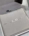 silver  chain necklace with crystal-studded oval pendants displayed in a black jewelry box.
