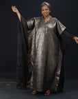 Model wearing the Royal Essence metallic kaftan dress with flowing sleeves and elegant shimmer finish.


