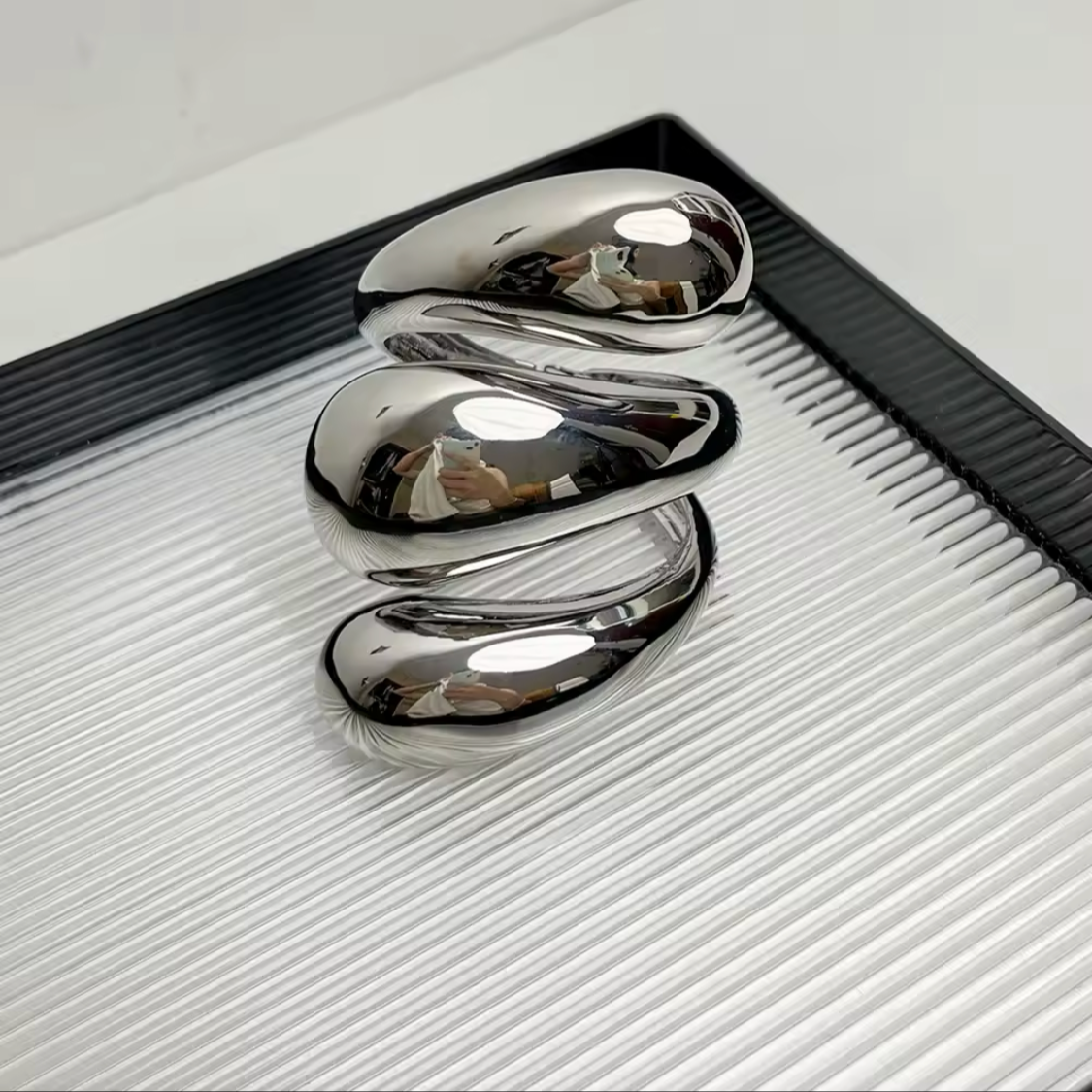 Three-layered metallic cuff bracelets in polished gold and silver finishes.