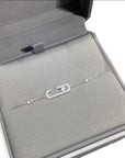 Silver  chain necklace with crystal-studded oval pendants displayed in a black jewelry box.
