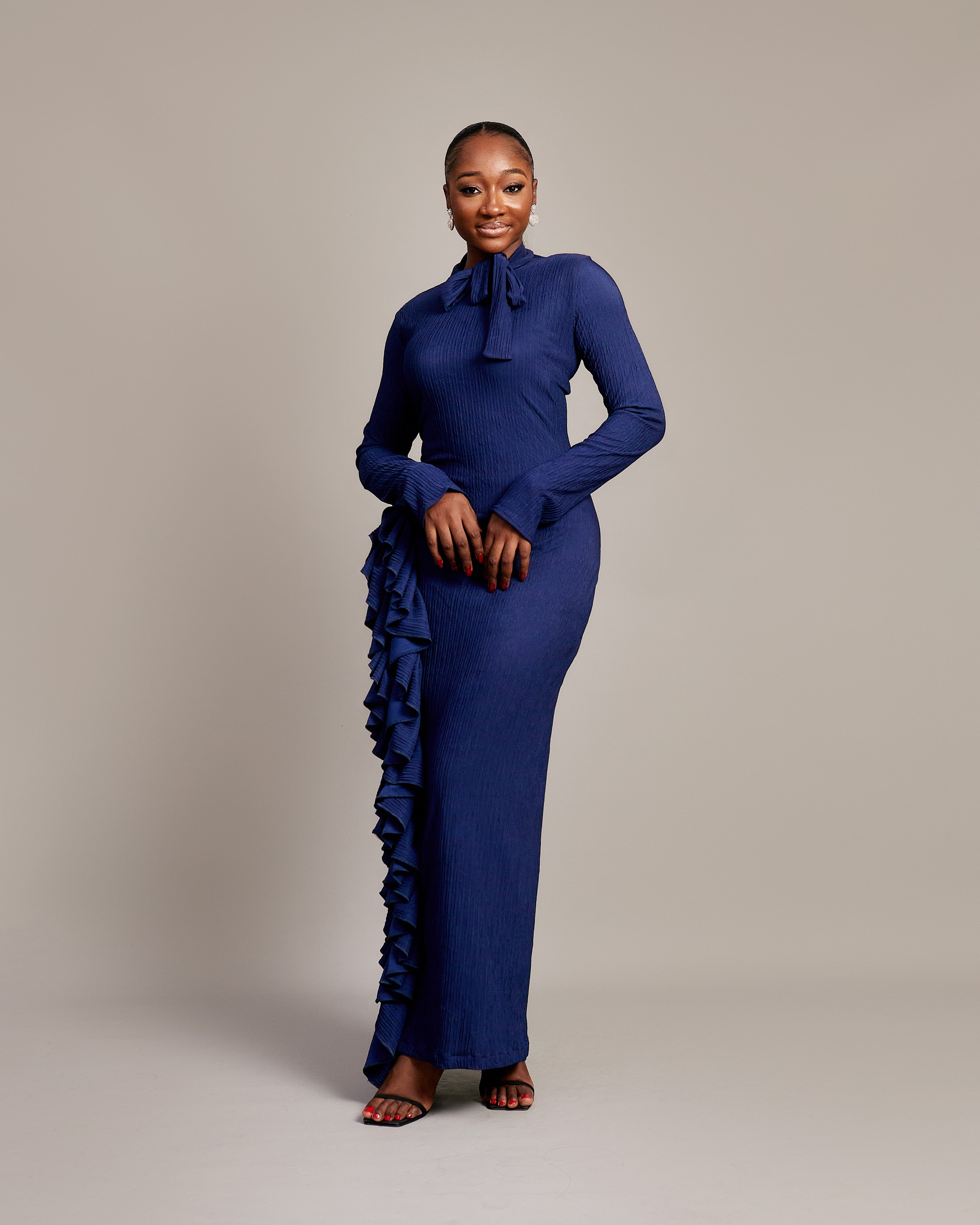  Amira Dress in navy blue with high neckline and bow tie detail.

