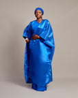 Woman wearing the Buubu Signature Set in royal blue, featuring a ruched floor-length gown, kimono overlay, and matching headwrap.
