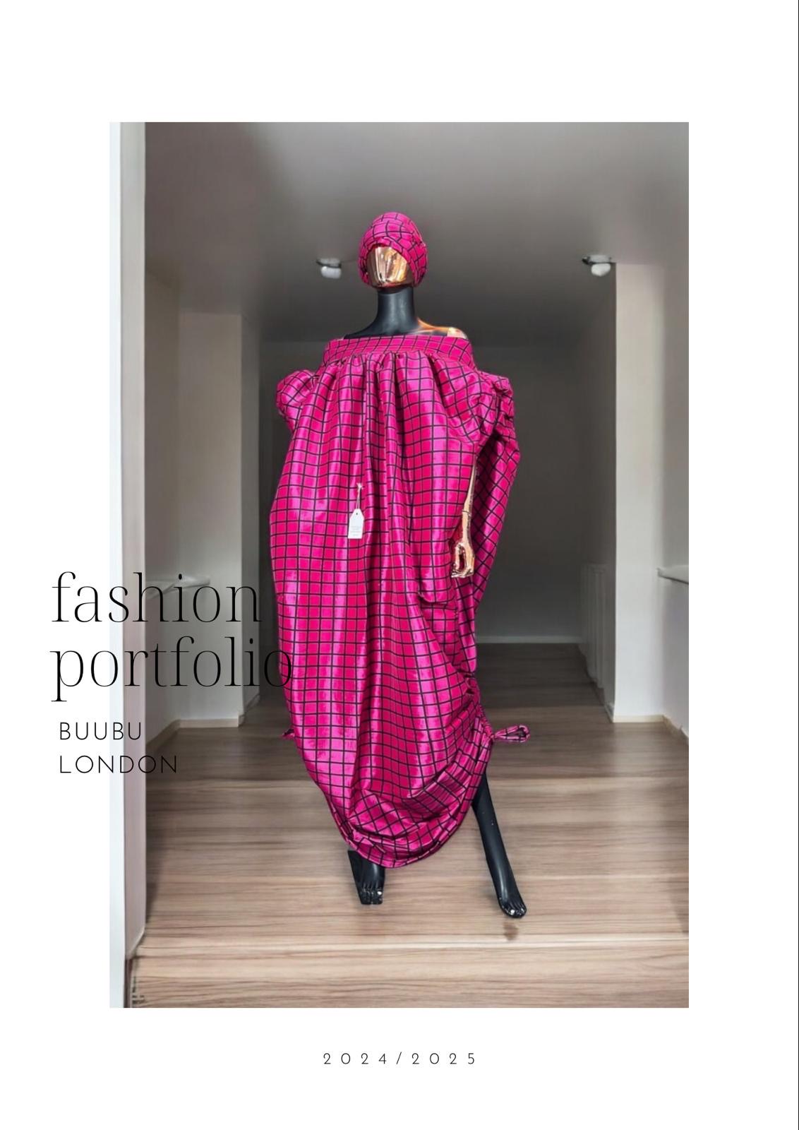 Pink off-shoulder boubou dress with black grid pattern, paired with a matching headwrap, displayed on a mannequin against a black paneled wall.
