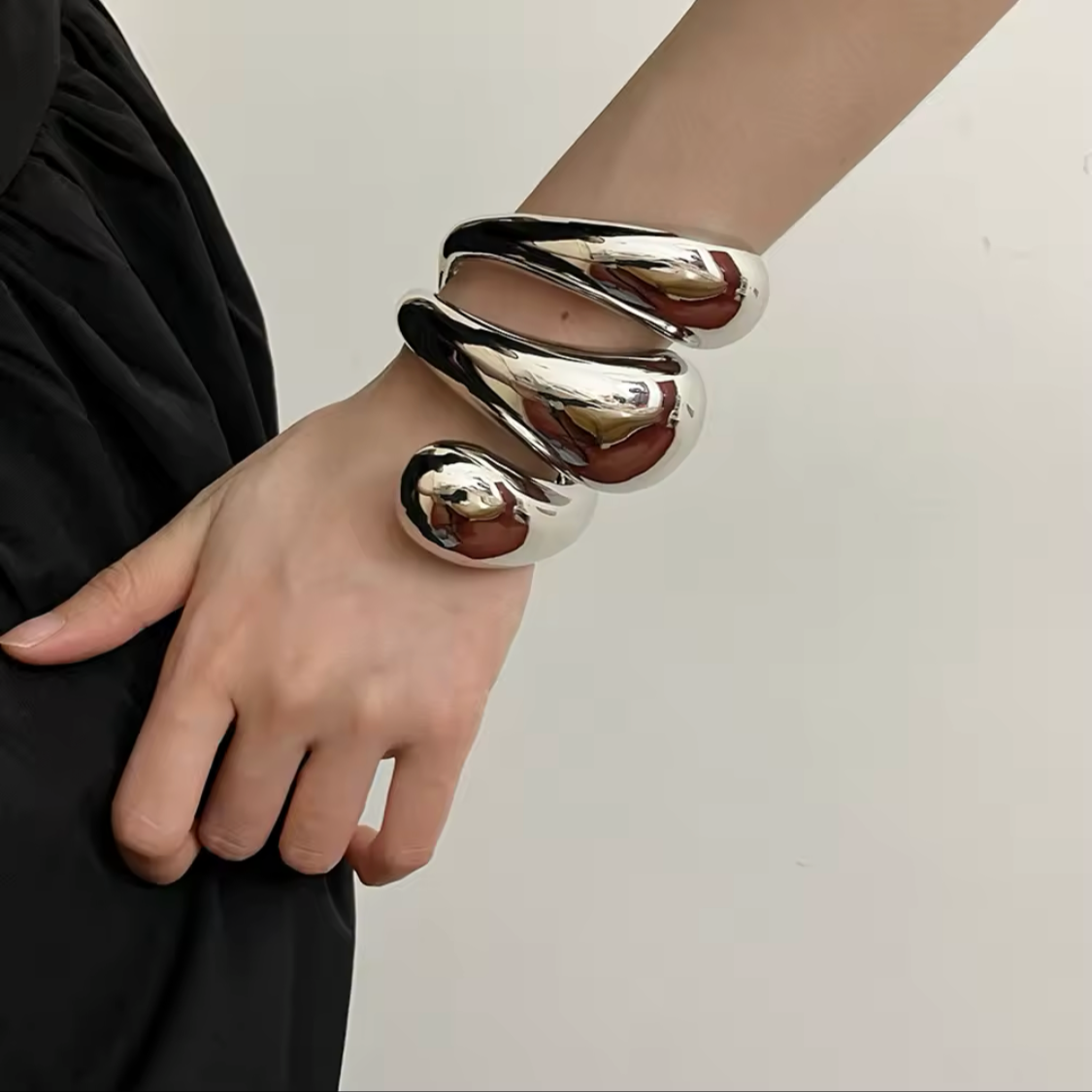 Three-layered metallic cuff bracelets in polished gold and silver finishes.