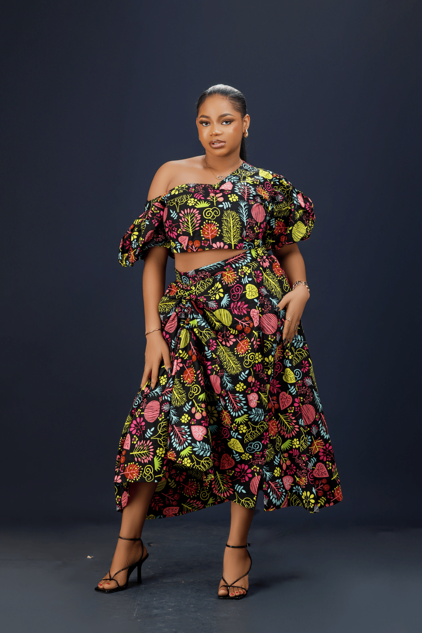 A woman wearing a vibrant floral maxi dress.
